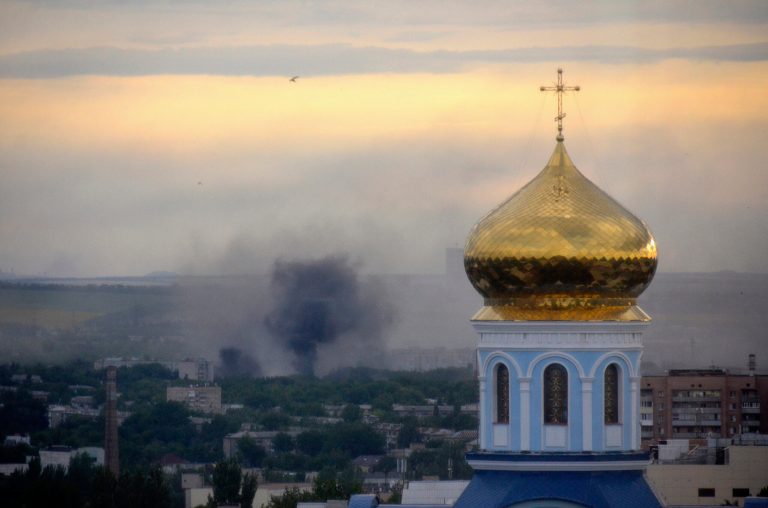 FILE - This July 14, 2014 file photo shows black smoke billowing following a mortar attack during fighting between Ukrainian government troops and pro-Russian fighters in Luhansk, Ukraine.  The United States is considering imposing unilateral sanctions on Russia over its threatening moves in Ukraine, a shift in strategy that reflects the Obama administration's frustration with Europe's reluctance to take tougher action against Moscow, according to U.S. and European officials. (AP Photo, Yuri Snegirev, Rossiyiskaya Gazeta, File)