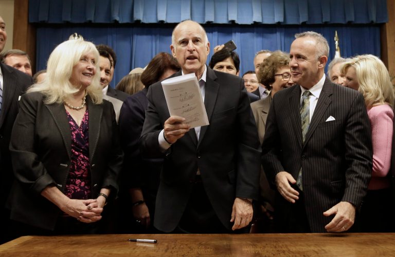 Gov. Jerry Brown holds up the measure he signed to  place a $7.5 billion water plan on the November ballot, Wednesday, Aug. 13, 2014, in Sacramento, Calif.  The measure replaces an existing water bond that was approved by a previous Legislature but was widely considered to costly and unlikely to be approved by voters. The water plan was approved by lawmakers earlier in the day after weeks of negotiations between Brown and legislative leaders.  Also seen are Assembly Minority Leader Connie Conway, R-Tulare, left,and Senate President Pro Tem Darrell Steinberg, D-Sacramento, right. (AP Photo/Rich Pedroncelli)