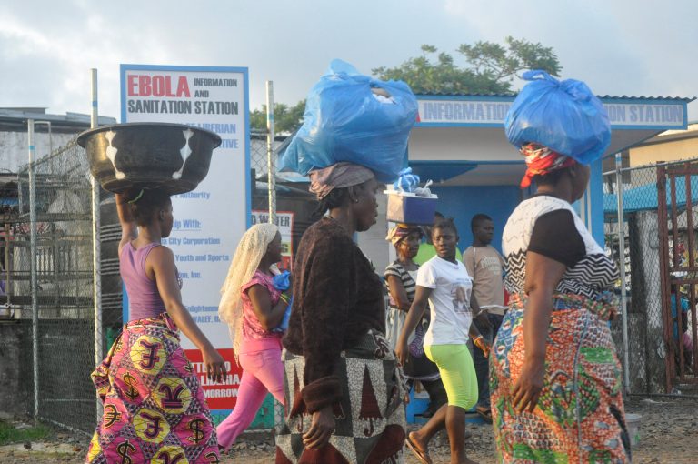 Liberia women walk past a sign warning people of the deadly Ebola virus in Monrovia, Liberia. Friday, Oct. 10, 2014. The number of people killed in the Ebola outbreak has risen above 4,000, according to the World Health Organization.  (AP Photo/ Abbas Dulleh)