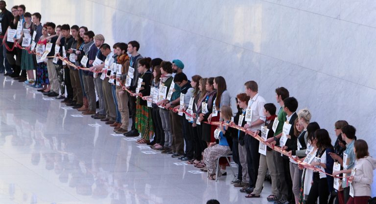   Local and international activists demonstrate inside a conferences center to demand urgent action to address climate change at the U.N. climate talks in Doha, Qatar, ,Saturday, Dec.8, 2012. After all-night wrangling, the latest draft agreements Saturday lacked the strong commitments on climate action and financing by rich countries that poor countries had hoped for. But they did include a text on 
