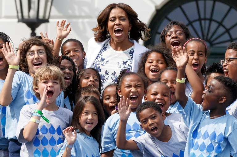 First lady Michelle Obama, a longtime supporter of healthier eating and physical fitness, is surrounded by children as she expands her push for America to drink more water, at a 