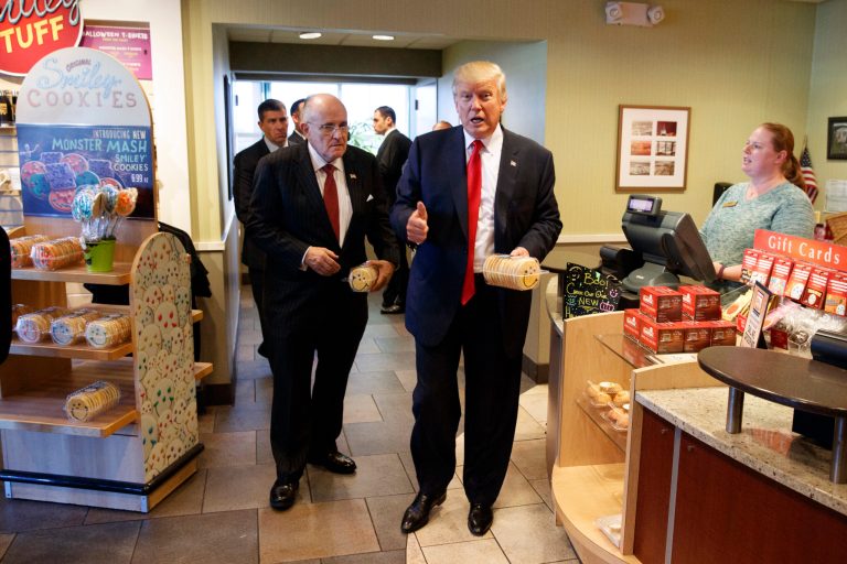 In this Oct. 10, 2016, photo, former New York mayor Rudy Giuliani, left, stands with then-Republican presidential candidate Donald Trump as he buys cookies during a visit to Eat'n Park restaurant in Moon Township, Pa. Children grumbling about healthier school meal rules championed by first lady Michelle Obama may have reason to cheer Trump's election. The billionaire businessman is a proud patron of quick food restaurants and is promising to curb federal regulations. (AP Photo/Evan Vucci)