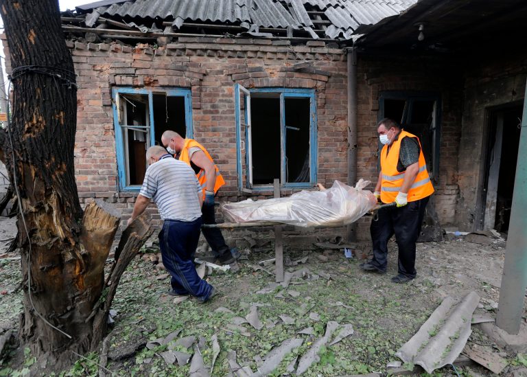 Rescue workers carry the body of woman who was killed during shelling in the Petrovsky district of Donetsk, eastern Ukraine, Tuesday, Aug. 5, 2014. Ukrainian troops took control of a checkpoint Tuesday on the western edge of the main rebel stronghold of Donetsk as the government makes further gradual advances to quash pro-Russian separatist forces in the east. (AP Photo/Sergei Grits)