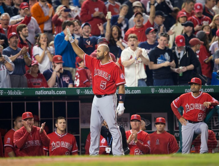Los Angeles Angels Albert Pujols (5) steps out of the visitors dugout to acknowledge the applause from the crowd after hitting his career 500th homer run against Washington Nationals Taylor Jordan in the fifth inning of a baseball game in Washington, Tuesday, April 22, 2014. (AP Photo/Pablo Martinez Monsivais)