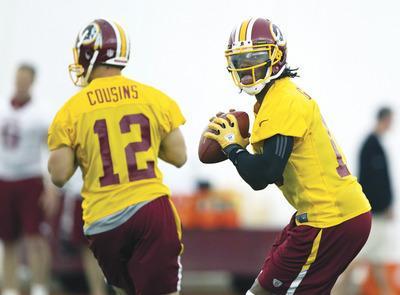 Evan Vucci/AP
Robert Griffin III practiced with the full Redskins roster during the team's first organized offseason workout Monday in Ashburn.