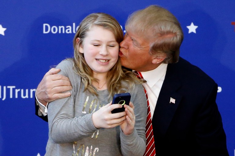Republican presidential candidate Donald Trump kisses an attendee after taking a selfie together during a campaign stop, Saturday in Portsmouth, N.H. (AP Photo/Matt Rourke)