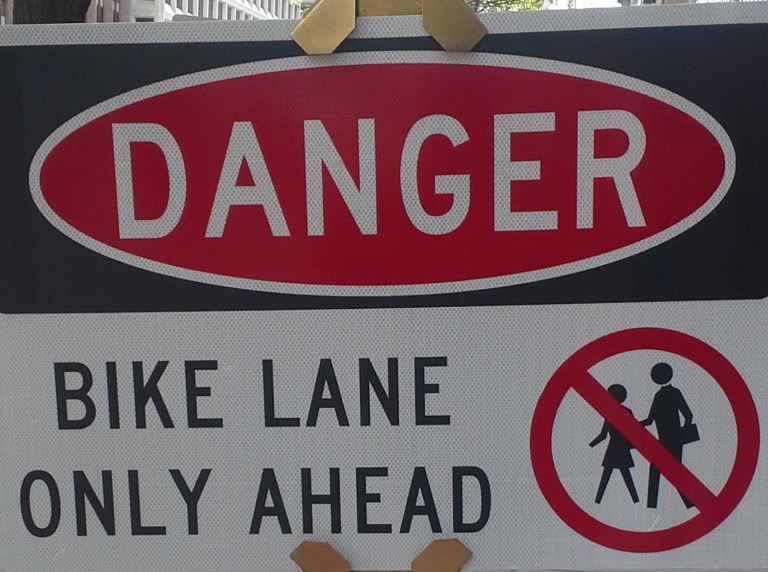 A new sign in front of Washington Post building demolition says 