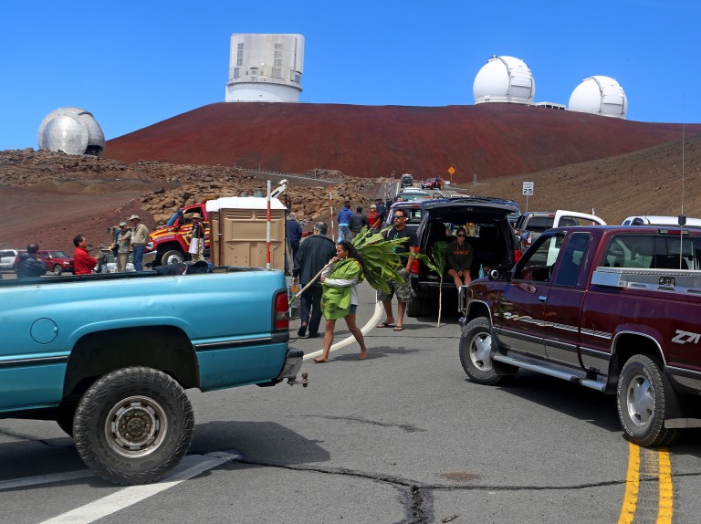 Protesters block vehicles from getting to the Thirty Meter Telescope groundbreaking ceremony site at Mauna Kea, Hawaii on Tuesday, Oct. 7, 2014. Protesters halted a groundbreaking and Hawaiian blessing ceremony for the construction of one of the world's largest telescopes. (AP Photo/Hawaii Tribune-Herald, Hollyn Johnson)