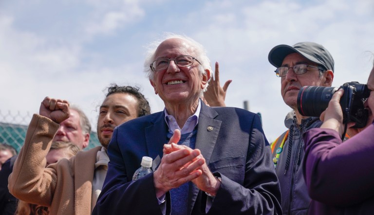 Sen. Bernie Sanders listens to speakers during a rally outside an Amazon facility on Staten Island in New York, Sunday, April 24, 2022. Sanders will resume his fight to enact a single payer healthcare system in the U.S. with Thursday's Senate Budget Committee hearing titled âMedicare for All: Protecting Health, Saving Lives, Saving Money.â (AP Photo/Seth Wenig)
