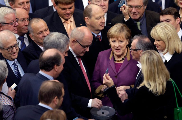   FILE - In this Nov. 30, 3012 file picture German Chancellor Angela Merkel casts her vote at the German federal parliament, Bundestag, in Berlin, Germany, Friday, Nov. 30, 2012. The German Parliament has given its overwhelming backing to a deal aimed at trimming Greece's debt load and keeping the country financially afloat. Lawmakers voted 473-100 on Friday to back the complex deal reached by European finance ministers earlier this week. Germany's chancellor says in an interview published saturday Dec. 1, 2012 she understands the frustration felt by many Germans over the repeated bailout programs for Greece. But Angela Merkel also insists that helping debt-ridden Greece is in her country's self-interest because it helps stabilize the 17-nation eurozone on which Germany's prosperity depends. (AP Photo/Michael Sohn, File)  