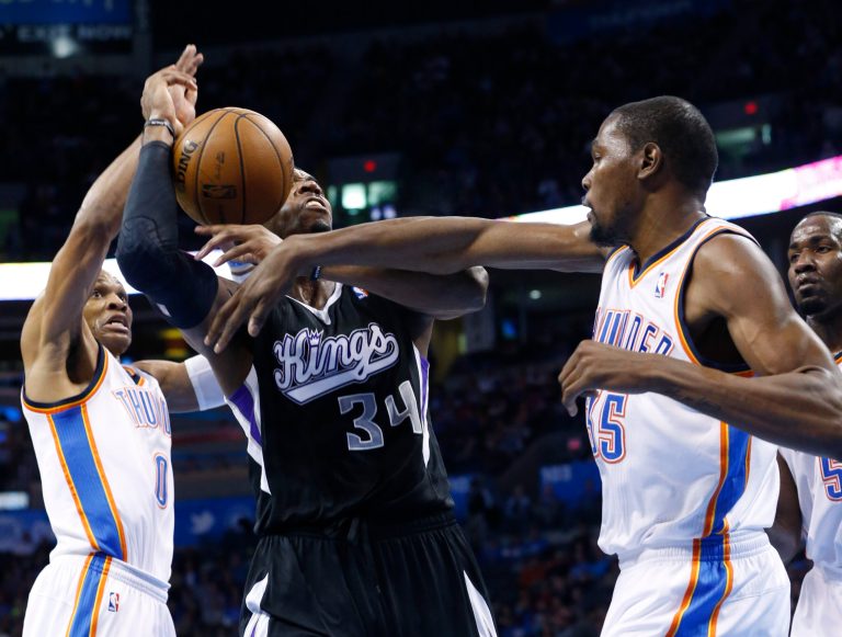   Oklahoma City Thunder forward Kevin Durant (35) knocks the ball away from Sacramento Kings forward Jason Thompson (34) in front of teammate guard Russell Westbrook (0) during the second quarter of an NBA basketball game in Oklahoma City, Friday, Dec. 14, 2012. (AP Photo/Sue Ogrocki)  