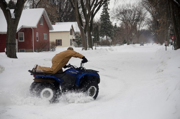 Eric, a Moorhead, Minn. man who did not give his last name, plays with an ATV after a snowstorm left city streets slick on Monday, March 4, 2013. (AP Photo/Minnesota Public Radio, Nathaniel Minor)