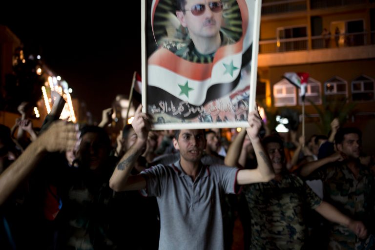 Syrian soldiers celebrate Bashar Assad's presidential re-election in Damascus, Syria, Wednesday June 4, 2014. Assad has been re-elected in a landslide, officials said Wednesday, capturing another seven-year term in the middle of a bloody 3-year-old uprising against his rule that has devastated the country. (AP Photo/Dusan Vranic)