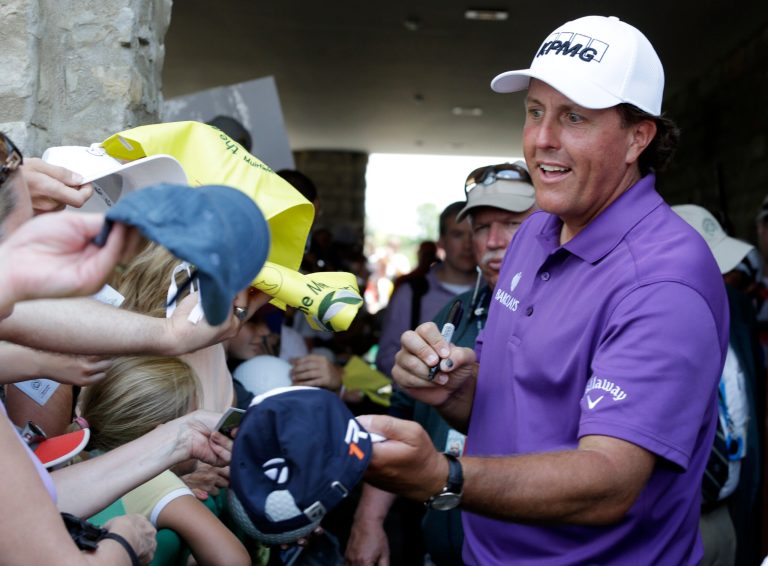 Phil Mickelson signs autographs for fans following his third round of the Memorial golf tournament Saturday, May 31, 2014, in Dublin, Ohio. (AP Photo/Darron Cummings)