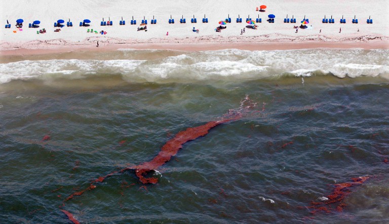 In this 2010 file photo, oil slicks move toward the beach in Gulf Shores, Ala. Friday's spending bill reinstated a tax of 9-cents-per-barrel of oil. The tax funds the the Oil Spill Liability Trust Fund, which helps pay for the cleanup of oil spills such as the BP Deepwater Horizon spill in the Gulf of Mexico in 2010. (AP Photo/Dave Martin, File )