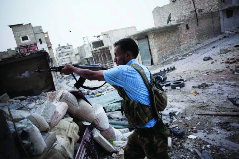 FILE - In this Saturday, Oct. 20, 2012 file photo, a Free Syrian Army fighter shoots his machine gun towards Syrian Army positions in the Amriya district of Aleppo, Syria. Piece by piece, Syria's rebels are slowly starting to expand their arsenal and get their hands on more advanced weapons, something that has been their constant aim in the 19-month-old uprising against the regime of President Bashar Assad. The process still appears to be haphazard and improvised: Far from a reliable, organized pipeline, it often remains a scramble by individual units in the highly fragmented rebel forces to obtain what they can. Most units still rely on their staple arsenal of automatic weapons, hand grenades and rocket-propelled grenades. (AP Photo/ Manu Brabo, File)