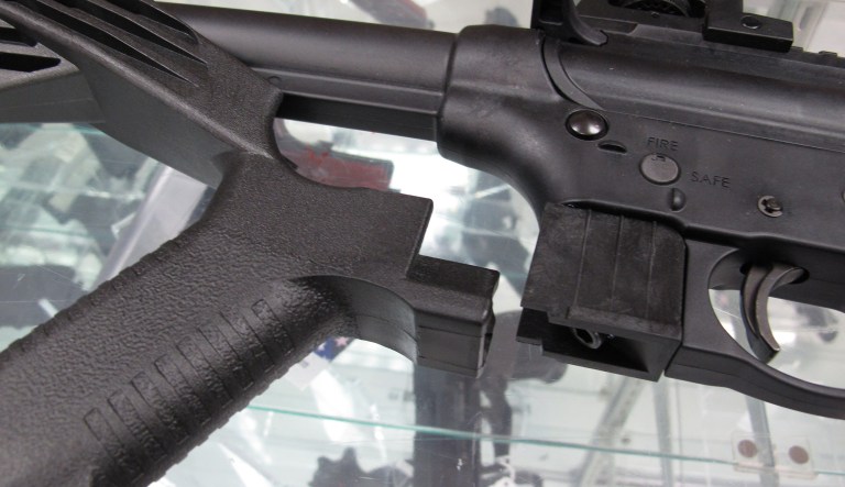 This Feb. 1, 2013 photo shows a bump stock next to a disassembled .22-caliber rifle. (AP Photo/Allen Breed)