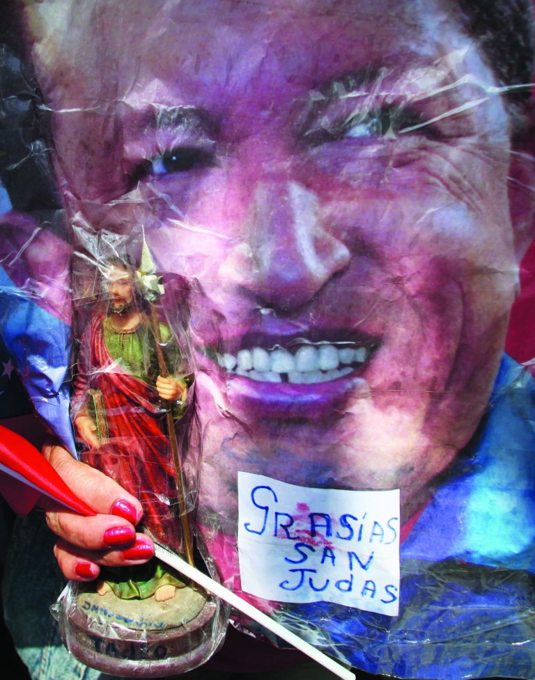 A woman holds a painting of President Hugo Chavez as supporters gather around Bolivar square after his return to the country in Caracas, Venezuela, Monday, Feb. 18, 2013. Chavez returned to Venezuela early Monday after more than two months of medical treatment in Cuba following cancer surgery. The government didn't offer an explanation as to why Chavez made his surprise return while he is undergoing other treatments that have not been specified.(AP Photo/Fernando Llano)