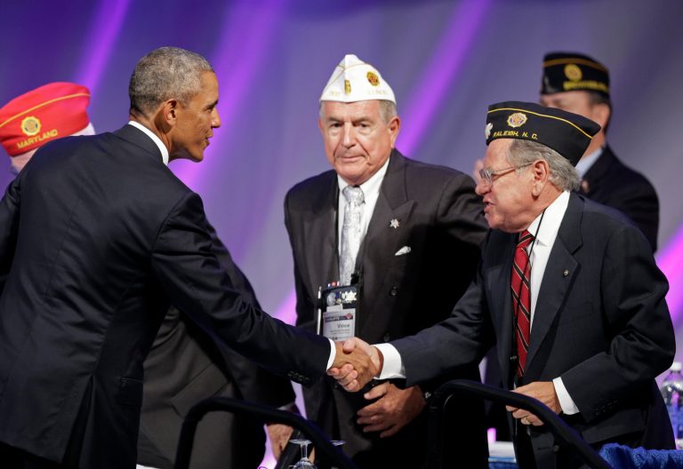 President Barack Obama greets legionnaires before speaking at the American Legion national convention in Charlotte, N.C., Tuesday, Aug. 26, 2014. (AP Photo/Chuck Burton)