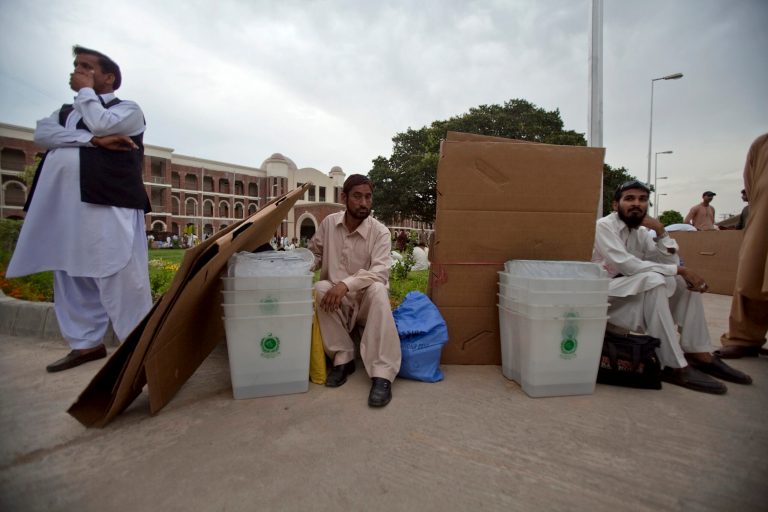 Pakistani election workers wait for transport after collecting polling material from an election office in Rawalpindi, Pakistan, Friday, May 10, 2013. Pakistan is scheduled to hold parliamentary elections on May 11, the first transition between democratically elected governments in a country that has experienced three military coups and constant political instability since its creation in 1947.(AP Photo/Anjum Naveed)