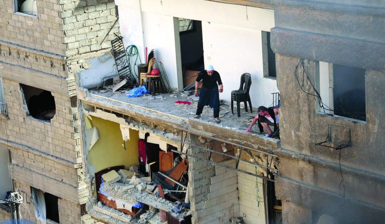In this photo released by the Syrian official news agency SANA, Syrian citizens are seen on a damaged building that destroyed by a car bomb, at Jaramana neighborhood, in Damascus, Syria, Monday Oct. 29, 2012. A Syrian government official says a car bomb in a Damascus suburb has killed 10 people. The official said the blast on Monday in Jaramana also wounded 41 people and caused heavy damage. He spoke on condition of anonymity because he was not authorized to speak to the media. (AP Photo/SANA)