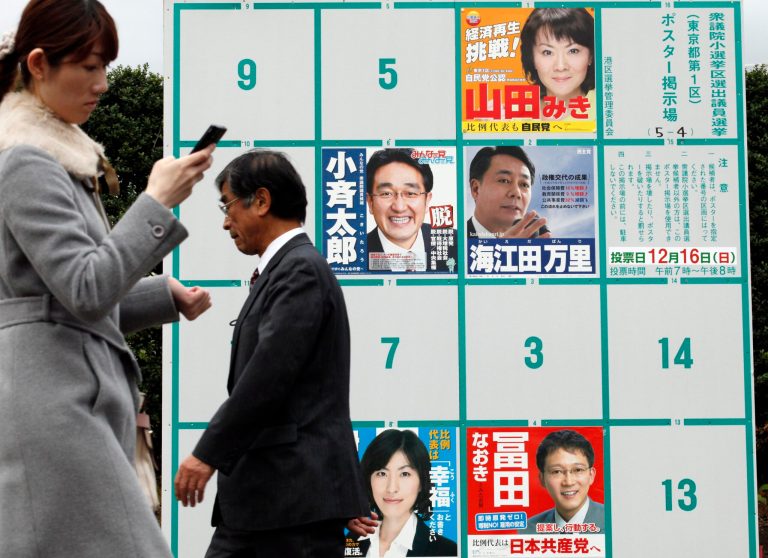   People walk by candidates' poster boards for parliamentary elections in Tokyo Tuesday, Dec. 4, 2012. Leaders for Japan's biggest political parties kicked off Tuesday the campaign for parliamentary elections to be held in less than two weeks with visits to nuclear crisis-hit Fukushima prefecture. (AP Photo/Koji Sasahara)  