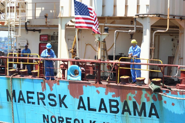 FILE - In this Nov. 22, 2009 file photo, crew members work aboard the U.S.-flagged Maersk Alabama after the ship docked in the harbour of Mombasa, in Kenya. Police in the Indian Ocean island nation of Seychelles said Wednesday, Feb. 19, 2014 that two American security officers were found dead Tuesday in a cabin on the Maersk Alabama, the ship hijacked by pirates in 2009, an event dramatized in the movie 