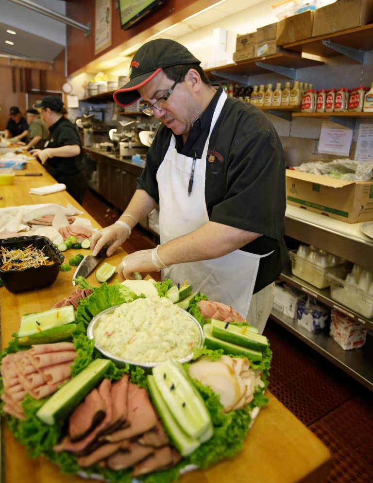 In this Friday, June 6, 2014 photo, Kenny Kurland prepares a deli meat and cheese platter at Corky & Lenny's Restaurant & Deli in Woodmere Village, Ohio. The University of Michigan issues its index of consumer sentiment for July on Friday, Aug. 1, 2014. (AP Photo/Tony Dejak)