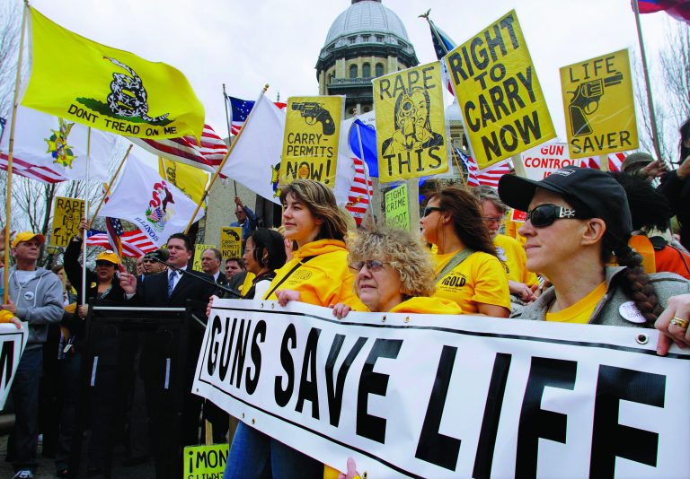 FILE - In this March 7, 2012 file photo taken in Springfield, Ill., members of the pro-gun group Guns Save Life rally at the Illinois State Capitol. The divide between those who favor gun control and those who don't has existed for decades, separating America into hostile camps of conservative vs. liberal, rural vs. urban. As the nation responds to the massacre of 20 children and six adults in Newtown, Conn., the gulf has rarely felt wider than now. (AP Photo/Seth Perlman, File)