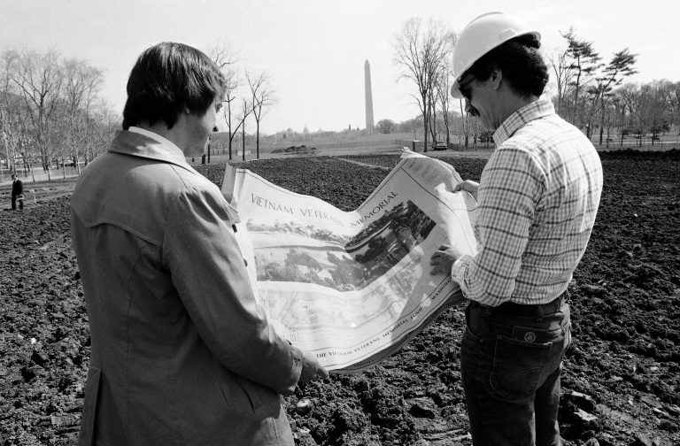 Jan Scruggs, left, president of the Vietnam Veterans Memorial Fund and Gary Wright the project engineer for the memorial look over plans for the project in Washington on March 23, 1982, which will be built on this site near the Washington Monument. Groundbreaking will be on March 26. (AP Photo/Bill Auth)