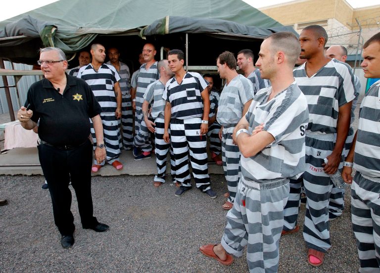 Inmates gather next to Maricopa County Sheriff Joe Arpaio as he walks through a Maricopa County Sheriff's Office jail called 