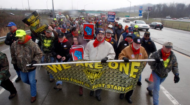 Mine workers and leaders from unions representing steelworkers, farmers, teachers, maritime workers and others march in a labor rally along State Route 21 to the Greene County Fairgrounds in Waynesburg, Pa. The coal industry that helped build southwestern Pennsylvania has declined for years. (AP Photo/Keith Srakocic)