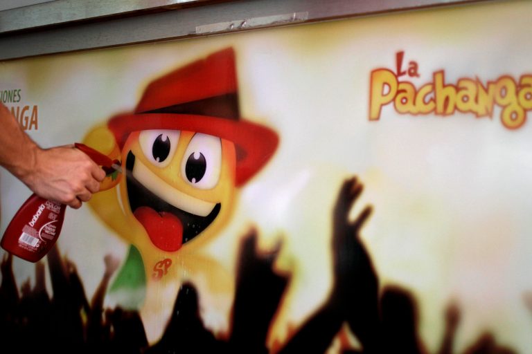   In this June 10, 2012 photo, design student Alejandro Perez sprays water on a advertisement sign promoting La Pachanga, a private cafeteria, preparing to attach it to the serving bar in Havana. Perez and a team of students helped design the cafeteria's mascot and ad campaign. For decades, Communist-run Cuba has essentially been free of commercial advertising. But it's a knotty problem for thousands of budding entrepreneurs who have embraced President Raul Castro's push for limited free-market reform. So they're turning to guerrilla marketing. (AP Photo/Franklin Reyes)  