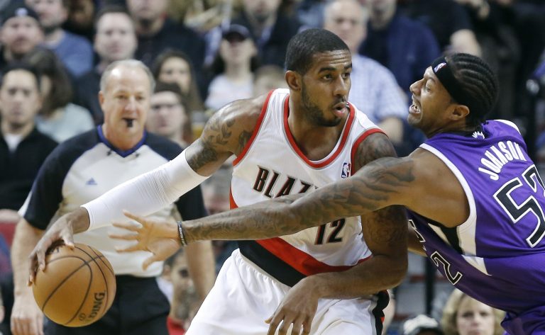   Portland Trail Blazers forward LaMarcus Aldridge, left, works the ball in against Sacramento Kings forward James Johnson during the first quarter of an NBA basketball game in Portland, Ore., Wednesday, Dec. 26, 2012. (AP Photo/Don Ryan)  