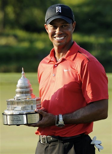 Tiger Woods poses with the trophy on the 18th green after winning the AT&T National golf tournament at Congressional Country Club in Bethesda, Md., Sunday, July 1, 2012. (AP Photo/Nick Wass)