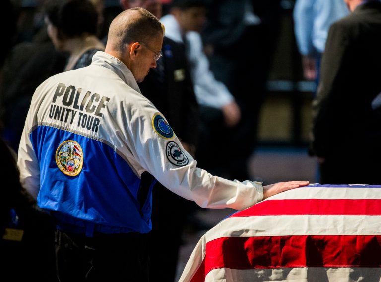 A member of the Police Unity Tour stops to touch the casket of Dallas Police officer Patrick Zamarripa after funeral services on Saturday, July 16, 2016. (Ashley Landis /The Dallas Morning News via AP, Pool)