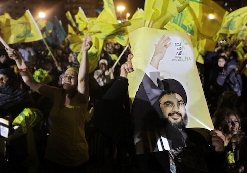 In this photo taken Tuesday, July 26, 2011, Hezbollah supporters wave the party's flags and carry pictures of Hezbollah leader Hassan Nasrallah during a rally marking the fifth anniversary of the 2006 Israel-Hezbollah war, in Beirut's southern suburb, Lebanon. (AP Photo/Bilal Hussein)