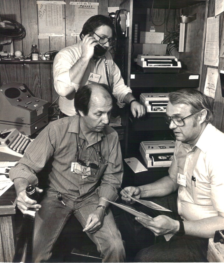 Former Washington photo editor Toby Massey, right, and Florida photo editor Phil Sandlin, left, edit photos at Kennedy Space Center during an early Space Shuttle launch as photograher Steve Pyle, rear,  coordninates transmissions with New York.   Massey, a photographer and photo editor who directed coverage of presidents and political conventions as well as natural disasters, the space program and sporting events during a 38-year career with The Associated Press, died Thursday, Aug. 21, 2014. He was 80. (AP Photo/Phil Sandlin)