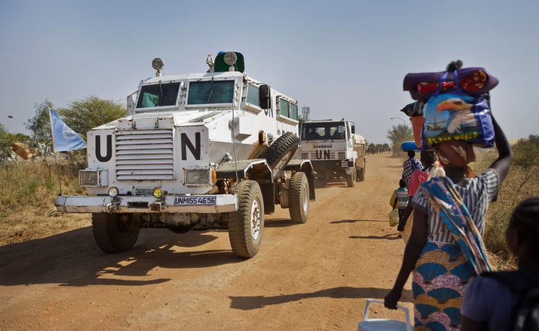 A United Nations armored vehicle passes displaced people walking towards the U.N. camp where they have sought shelter in Malakal, South Sudan, Monday, Dec. 30, 2013. AP Photo/Ben Curtis)