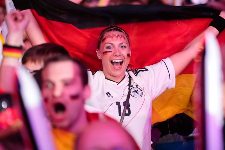 German soccer fans celebrate after their team scores at the Brazil World Cup semi final being played in Belo Horizonte, Brazil, between Germany and Brazil at a public viewing event called 'Fan Mile' in Berlin, Tuesday, July 8, 2014. (AP Photo/Markus Schreiber)