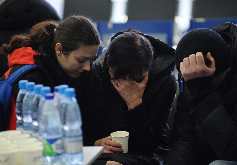 A Russian Emergency Situations Ministry employee, left, tries to comfort a relative of the plane crash victims at the Rostov-on-Don airport, about 950 kilometers (600 miles) south of Moscow, Russia Saturday, March 19, 2016. (AP Photo)