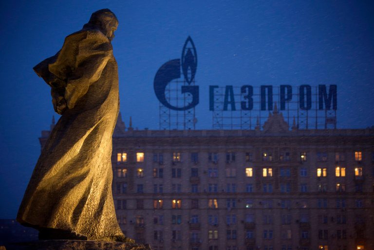FILE - In this March 4, 2014 file photo, a monument to Ukrainian poet and writer Taras Shevchenko is silhouetted against an apartment building with a sign advertising Russia's natural gas giant Gazprom, in Moscow, Russia. Unsatisfied with a fragile cease-fire in Ukraine, the United States and the European Union levied new sanctions Friday against major Russian banks and defense companies, as well as penalties aimed at curtailing Russia's ability to develop oil and gas projects. But the restrictions on Russia's energy sector were carefully crafted to avoid impacting the country's current production of oil and gas, a move that would raise global energy prices at time of weak economic growth. Russia is the largest oil exporter outside of OPEC and the most important supplier of natural gas to Europe. (AP Photo/Alexander Zemlianichenko, file)