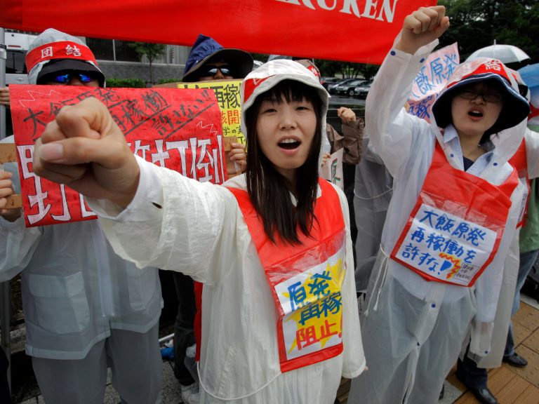   Demonstrators raise clenched fists during a rally, protesting against restarting the Ohi nuclear power plant's reactors in front of the prime minister's official residence in Tokyo, Saturday, June 16, 2012. Japan moved closer to restarting the nuclear reactors for the first time since last year's earthquake and tsunami led to a nationwide shutdown. A slogan, center, reads: 