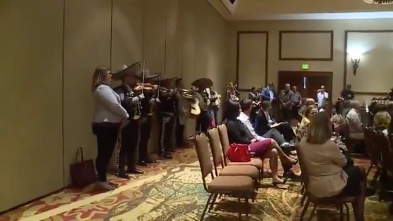 Gardner was hosting a meeting with the Colorado Springs Chamber of Commerce when the band began playing at the back of the room as the senator was answering questions. (Image courtesy screenshot)