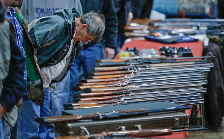 FILE - In this Jan. 26, 2013 file photo, a customer looks over shotguns on display at the annual New York State Arms Collectors Association Albany Gun Show at the Empire State Plaza Convention Center in Albany, N.Y. After struggling to sway both state and federal lawmakers, proponents of expanding background checks for gun sales are now exploring whether they will have more success by taking the issue directly to voters. While advocates generally prefer that new gun laws be passed through the legislative process, especially at the national level, they are also concerned about how much sway the National Rifle Association has with lawmakers. Washington state Rep. Jamie Pedersen, a Democrat who had sponsored unsuccessful legislation on background checks at the state level, said a winning ballot initiative would make a statement with broad implications. (AP Photo/Philip Kamrass, File)