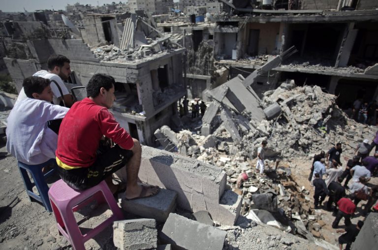 Palestinians search in the rubble of a destroyed house where eight members of the Al Haj family were killed in a strike early morning in Khan Younis refugee camp, southern Gaza Strip on Thursday, July 10, 2014. Israel dramatically escalated its aerial assault in Gaza Thursday hitting hundreds of Hamas targets, as Palestinians reported more than a dozen of people killed in strikes that hit a home and a beachside cafe and Israel's missile defense system once again intercepted rockets fired by militants at the country's heartland. (AP Photo/Khalil Hamra)
