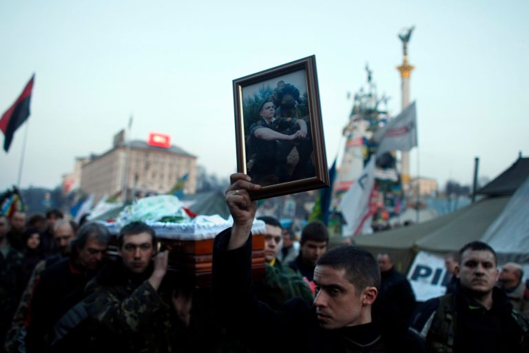A man carries a photo of an anti-government protester killed in clashes with the police, during a funeral procession at Independence Square in Kiev, Ukraine, on Friday. (AP Photo/ Marko Drobnjakovic)