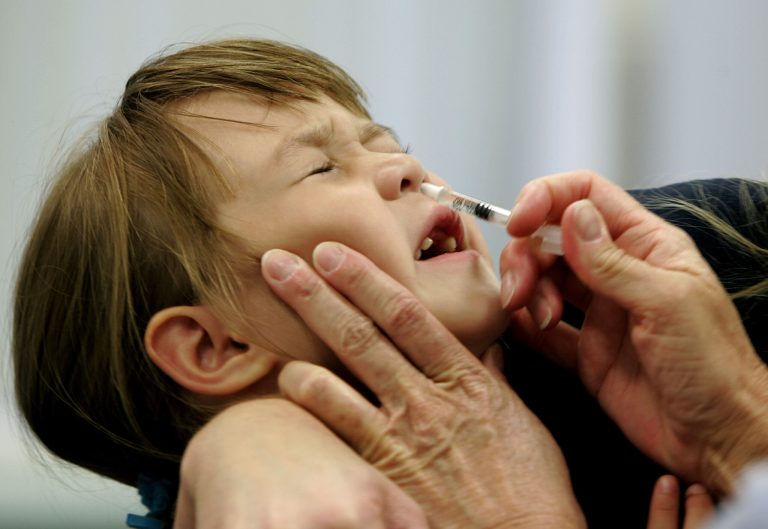 FILE - In this Oct. 4, 2005 file photo, Danielle Holland reacts as she is given a new FluMist influenza vaccination in St. Leonard, Md. A Federal advisory panel agreed on Wednesday, June 25, 2014, to tell doctors that FluMist nasal spray is a bit better at preventing flu in healthy young kids. (AP Photo/Chris Gardner, File)