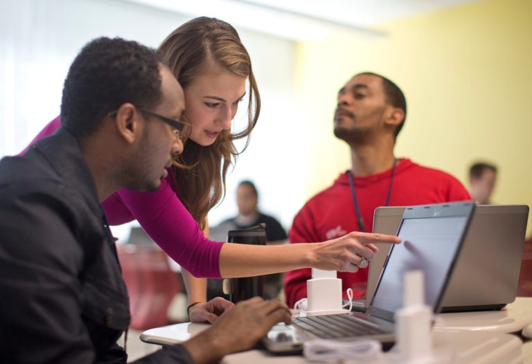 Kaylin Wainwright, center, works with student Natnael Gebremariam, left, at a computer during a General Educational Development test preparation class at the Sonia Gutierrez Campus of the Carlos Rosario International Public Charter School in Washington. (AP/Carolyn Kaster)