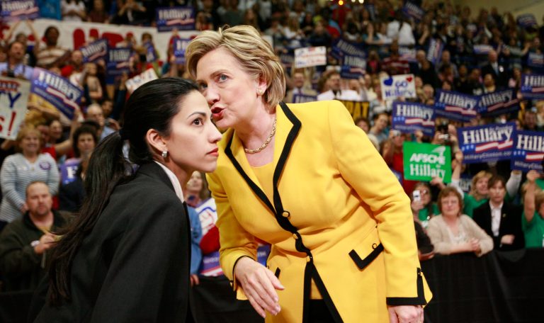Democratic presidential front-runner Hillary Clinton has a word with aide Huma Abedin at the start of a campaign rally at Capital High School in Charleston, W.Va., Wednesday, March 19, 2008. (AP Photo/Charles Dharapak)